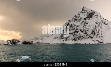 Die Landschaft von Point Wild auf der Elefanteninsel ist abgelegen und verboten mit steilen, schneebedeckten Bergen, felsigen Felsvorsprüngen und stürmischem Himmel Stockfoto