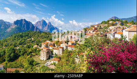 EVisa, Korsika, ein malerisches Dorf am Hügel mit roten Häusern, lebendigen Blumen und atemberaubendem Blick auf die Berge. Stockfoto