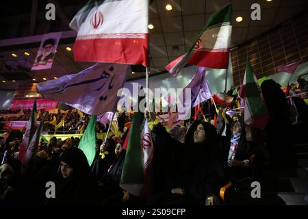 Teheran, Iran. Dezember 2024. Iranische Frauen schwenken iranische Flaggen während einer Zeremonie zum Jahrestag des Todes von Generalmajor Qasem Soleimani, der am 3. Januar 2020 bei einem US-Drohnenangriff in Bagdad im Azadi Indoor Stadium im Westen Teherans getötet wurde. (Kreditbild: © Rouzbeh Fouladi/ZUMA Press Wire) NUR REDAKTIONELLE VERWENDUNG! Nicht für kommerzielle ZWECKE! Stockfoto