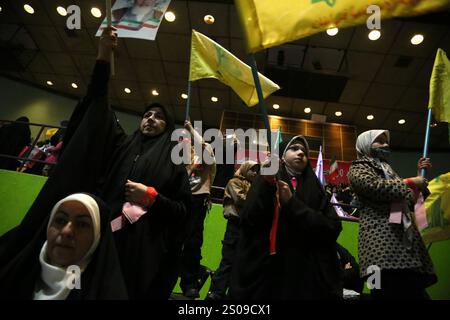 Teheran, Iran. Dezember 2024. Iranische Frauen schwenken Hisbollah-Fahnen während einer Zeremonie zum Jahrestag des Todes von Generalmajor Qasem Soleimani, der am 3. Januar 2020 bei einem US-Drohnenangriff in Bagdad im Azadi Indoor Stadium im Westen Teherans getötet wurde. (Kreditbild: © Rouzbeh Fouladi/ZUMA Press Wire) NUR REDAKTIONELLE VERWENDUNG! Nicht für kommerzielle ZWECKE! Stockfoto