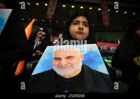 Teheran, Iran. Dezember 2024. Ein iranisches junges verschleiertes Mädchen trägt ein Porträt von Generalmajor Qasem Soleimani, der bei einem US-Drohnenangriff in Bagdad am 3. Januar 2020 während seiner Jubiläumsfeier im Azadi Indoor Stadium im Westen Teherans getötet wurde. (Kreditbild: © Rouzbeh Fouladi/ZUMA Press Wire) NUR REDAKTIONELLE VERWENDUNG! Nicht für kommerzielle ZWECKE! Stockfoto