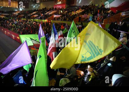 Teheran, Iran. Dezember 2024. Iranische Frauen schwenken Hisbollah-Fahnen während einer Zeremonie zum Jahrestag des Todes von Generalmajor Qasem Soleimani, der am 3. Januar 2020 bei einem US-Drohnenangriff in Bagdad im Azadi Indoor Stadium im Westen Teherans getötet wurde. (Kreditbild: © Rouzbeh Fouladi/ZUMA Press Wire) NUR REDAKTIONELLE VERWENDUNG! Nicht für kommerzielle ZWECKE! Stockfoto