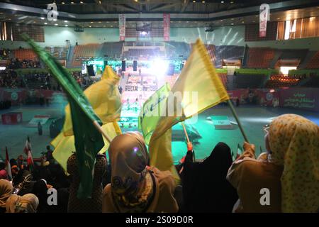 Teheran, Iran. Dezember 2024. Iranische Frauen schwenken Hisbollah-Fahnen während einer Zeremonie zum Jahrestag des Todes von Generalmajor Qasem Soleimani, der am 3. Januar 2020 bei einem US-Drohnenangriff in Bagdad im Azadi Indoor Stadium im Westen Teherans getötet wurde. (Kreditbild: © Rouzbeh Fouladi/ZUMA Press Wire) NUR REDAKTIONELLE VERWENDUNG! Nicht für kommerzielle ZWECKE! Stockfoto