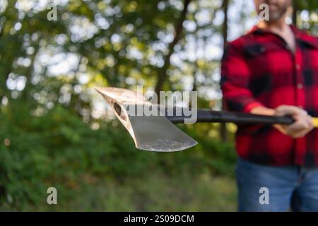 Brutaler Holzfäller. Holzfäller-Stil. Man Holzfäller mit Axtklinge. Axt im Mann, der draußen Holz hackt. Schneiden von Holz. Scharfe Klinge. Brutalität und Stockfoto