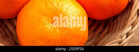 Leuchtend orange Mandarinen mit holpriger, strukturierter Schale in einem natürlichen Korb. Reife Bio-Zitrusfrüchte. Nahaufnahme. Draufsicht Stockfoto
