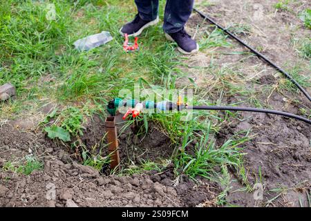 Installation der Tropfbewässerung. Verteilereinheit der Bewässerungsanlage im Garten im Frühjahr. Stockfoto