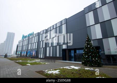 Weißrussland, Minsk - 26, 12, 2024: Es gibt ein großes und beeindruckendes Gebäude mit einem wunderschön dekorierten Weihnachtsbaum, der rechts oben steht Stockfoto