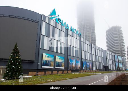 Weißrussland, Minsk - 26, 12, 2024: Es gibt ein großes und beeindruckendes Gebäude mit einem wunderschön dekorierten Weihnachtsbaum, der rechts oben steht Stockfoto