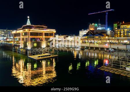 Das beleuchtete Resort am Seeufer im Zentrum von Coeur d'Alene, Idaho, USA, mit farbenfrohen Weihnachtslichtern an Gebäuden, Bäumen und Yachthafen. Stockfoto