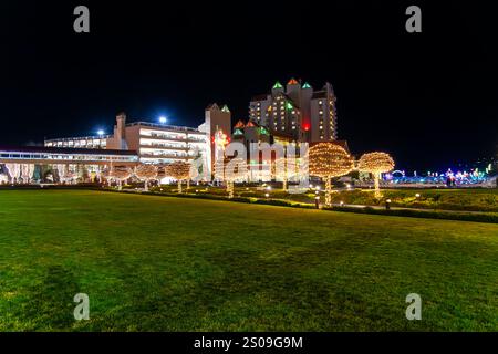 Das beleuchtete Resort am Seeufer im Zentrum von Coeur d'Alene, Idaho, USA, mit farbenfrohen Weihnachtslichtern an Gebäuden, Bäumen und Yachthafen. Stockfoto