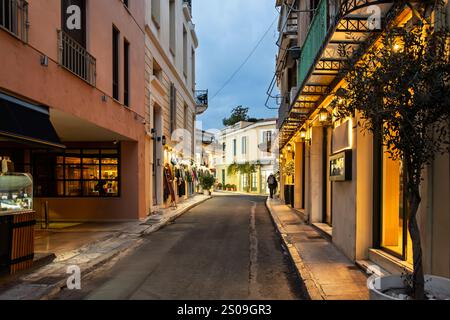 Späte Nacht auf einer beleuchteten schmalen Fußgängerzone mit Souvenirläden und Cafés im Plaka-Viertel von Athen, Griechenland. Stockfoto