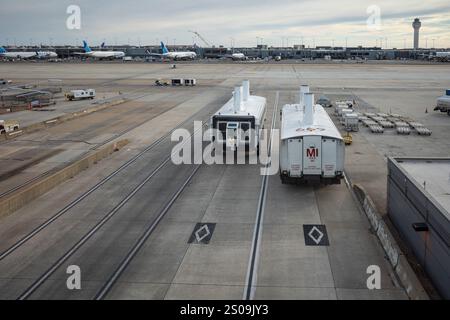 Eine geschäftige Szene am Flughafen Dulles, Washington, mit Bussen, die zwischen Terminals verkehren, eingerahmt vom Kontrollturm und geerdeten Flugzeugen. Stockfoto