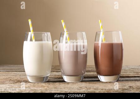 Verschiedene leckere Proteincocktails in Gläsern auf Holztisch Stockfoto