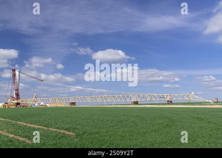 Nancy, Frankreich - Blick auf einen beige-burgunderroten Gitterkran Liebherr LG 1750 auf der Baustelle eines Windparks. Stockfoto