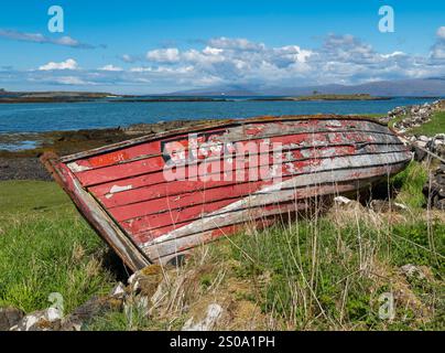 Überreste eines alten rot bemalten Holzklinkerbootes an der Küste nahe Broadford, Isle of Skye, Schottland, Großbritannien Stockfoto