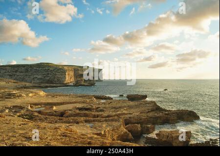 Eine Meereslandschaft mit einer Klippe namens Fungus Rock in der Nähe des Azure Fensters bei Sonnenuntergang, Gozo Island, Malta. Stockfoto