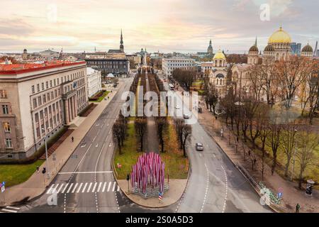 Aus der Vogelperspektive von Riga, Lettland, mit goldenen Kuppeln der Kathedrale Christi Christi, von Bäumen gesäumter zentraler Allee und moderner Kunstinstallation im Stockfoto