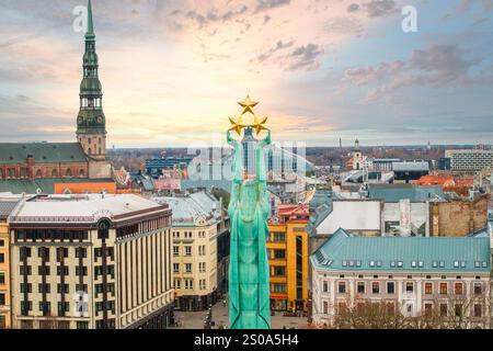 Das Bild zeigt eine Luftaufnahme von Riga, Lettland, und hebt das Freiheitsdenkmal und den Turm der Peterskirche vor einem historischen Stadtbild hervor. Stockfoto