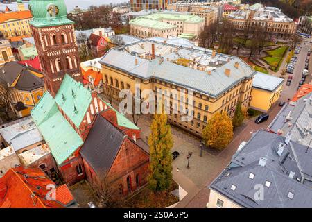 Aus der Vogelperspektive von Riga, Lettland, mit Blick auf die St. James's Cathedral mit ihrem Backsteinturm und dem grünen Dach. Historische und moderne Gebäude mischen sich im Herbst Stockfoto