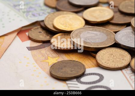 Ein Stapel Münzen und Scheine, darunter ein 50-Euro-Schein. Die Münzen haben verschiedene Größen und Farben Stockfoto