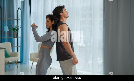 Kaukasisches junges Paar Mann Frau zusammen Hocken Pumpen Beine Muskeln Rücken an Rücken Pose gesunde Lebensweise körperliche Aktivität Übung Training Sport Stockfoto