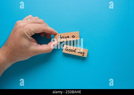 „Have a good day“ steht auf Holzblöcken, die auf blauem Hintergrund stehen Stockfoto