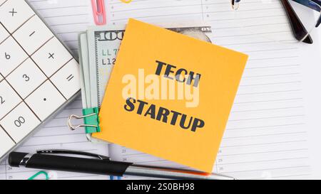 Der Begriff der Technik. Der konzeptionelle Text des TECHNISCHEN STARTUPS wird auf einem Aufkleber auf dem Hintergrund eines geöffneten Notizbuchs geschrieben. Stockfoto