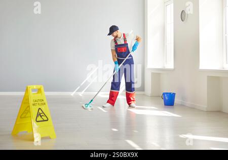 Männlicher Reiniger wischt Böden mit Einem Mopp für den Reinigungsservice ab Stockfoto