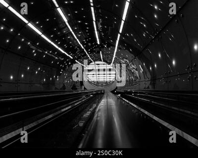 Ein Tunnel mit Lichtern an der Decke. Der Tunnel ist dunkel. Da ist ein Zug im Tunnel. Polen, Warschau 23.12.2024 Stockfoto