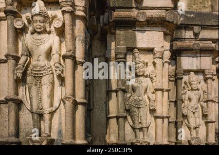 Hinduistische Steinskulpturen auf der Außenseite des antiken Kamakhya-Tempels, ca. 1565, die die Götter in ruhigen, friedlichen Haltungen in Indien darstellen. Stockfoto