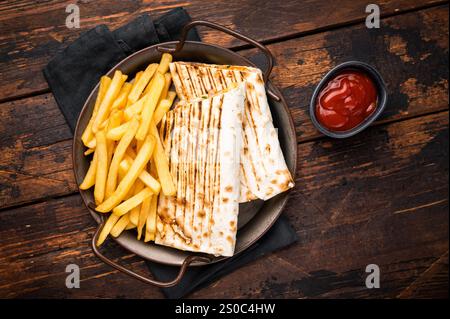 Döner Kebab, Shawarma mit Fleisch, Salat und pommes frites. Hölzerner Hintergrund. Draufsicht. Stockfoto