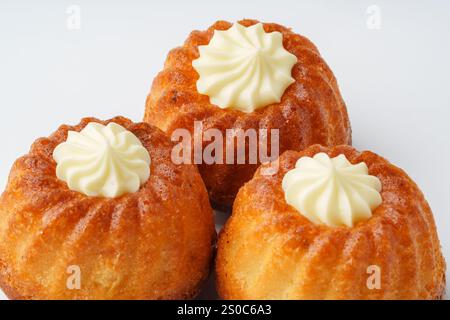 Köstliche Mini-Kuchen mit cremigen Zuckerguss-Toppings für eine süße Feier Stockfoto