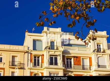 Appartementhaus in Madrid, Spanien. Klassische spanische Architektur. Gebäudefassade vor blauem Himmel. Herbst in einer Stadtstraße an sonnigem Tag. Gutes Wetter. Stockfoto