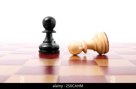Bauernhof nahe gefallenem schwarzem auf hölzernem Schachbrett vor weißem Hintergrund. Wettbewerbskonzept Stockfoto