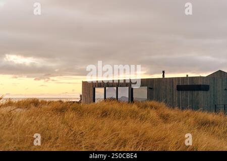 Fassade eines Designergebäudes aus Holz an der Küste. Stockfoto