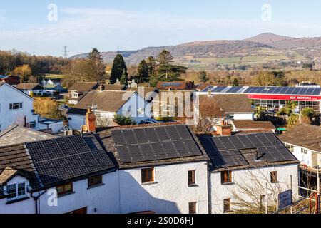 Solarpaneele auf Haus- und Geschäftsdächern in Village, Llanfoist, Wales, Großbritannien Stockfoto