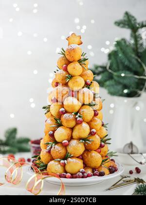 Weihnachten Desserts Donuts Rezept. Hüttenkäse runde Donuts in Form eines Weihnachtsbaums, dekoriert mit Preiselbeeren, Rosmarin und Puderzucker auf li Stockfoto