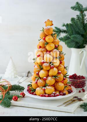 Weihnachten Desserts Donuts Rezept. Hüttenkäse runde Donuts in Form eines Weihnachtsbaums, dekoriert mit Preiselbeeren, Rosmarin und Puderzucker auf li Stockfoto