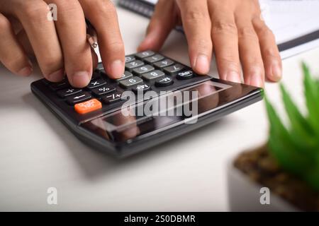 Machen Sie Geschäftsleute mit Taschenrechner hautnah, um die Finanzierung zu berechnen und Notizen zu schreiben, Buchhaltung am Schreibtisch zu erstellen und Budgetverwaltung zu verwalten. Finanzen, Budgets Stockfoto