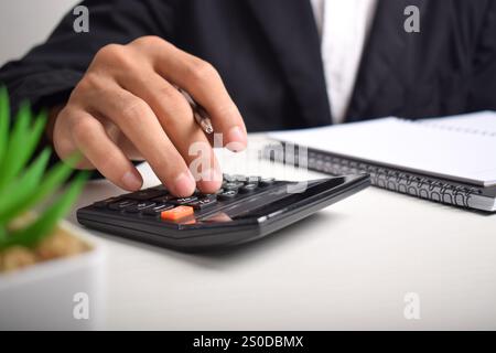 Buchhalter Geschäftsmann analysiert das Diagramm „Invoice Investment“ und drückt auf dem Dokument die Schaltfläche „Calculator“. Buchhalter Bankberater Und Auditor. Stockfoto