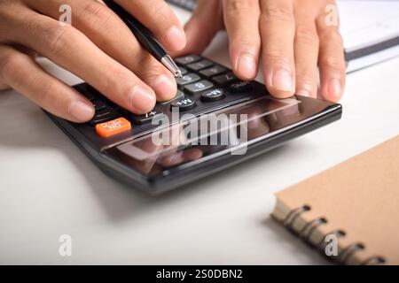 Machen Sie Geschäftsleute mit Taschenrechner hautnah, um die Finanzierung zu berechnen und Notizen zu schreiben, Buchhaltung am Schreibtisch zu erstellen und Budgetverwaltung zu verwalten. Finanzen, Budgets Stockfoto