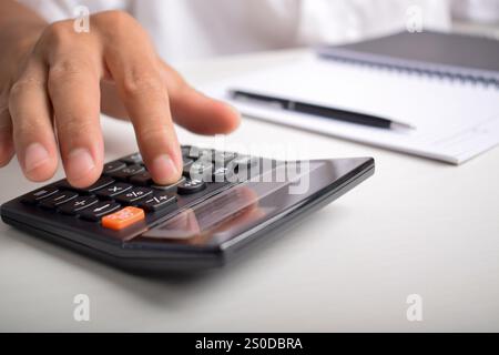 Machen Sie Geschäftsleute mit Taschenrechner hautnah, um die Finanzierung zu berechnen und Notizen zu schreiben, Buchhaltung am Schreibtisch zu erstellen und Budgetverwaltung zu verwalten. Finanzen, Budgets Stockfoto