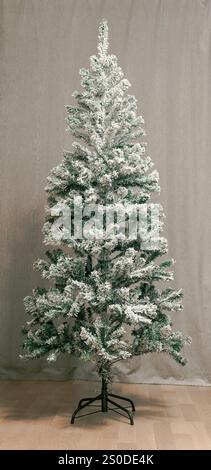 Künstlicher Weihnachtsbaum im Inneren mit Schnee bedeckt Stockfoto