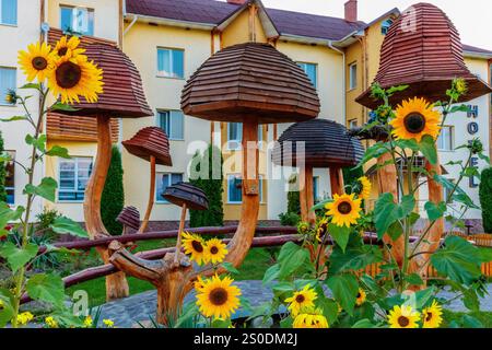 Ein Hotel mit Garten davor. Der Garten hat einen Haufen Sonnenblumen und Pilze Stockfoto