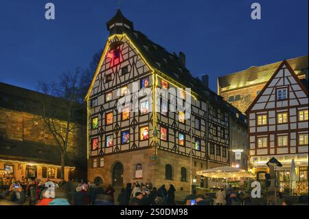 Pilatushaus, 1489 erbaut, ein historisches Stadthaus mit Adventskalender am 18. Dezember 2024 bei Dämmerung, das Kaiserschloss auf der rechten Seite, Tiergaertnert Stockfoto