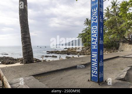 Tsunami-Gefahrenzone. Warnschild, Beschilderung der Fluchtwege im Falle eines weiteren Seebebens. Strandbereich und Küstenstraße in der Stadt Patong, K Stockfoto