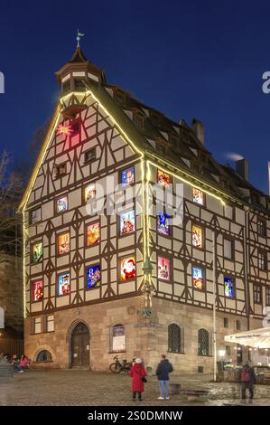 Pilatushaus, 1489 erbaut, ein historisches Stadthaus mit Adventskalender am 18. Dezember 2024 bei Dämmerung, das Kaiserschloss auf der rechten Seite, Tiergaertnert Stockfoto