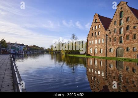 Historische Salzlager mit Reflexionen auf der Wasseroberfläche, Morgenlicht, Liebesbrücke, Hansestadt Lübeck, Schleswig-Holstein, Deutschland, Stockfoto