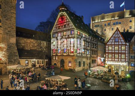 Pilatushaus, 1489 erbaut, ein historisches Stadthaus mit Adventskalender am 18. Dezember 2024 bei Dämmerung, das Kaiserschloss auf der rechten Seite, Tiergaertnert Stockfoto