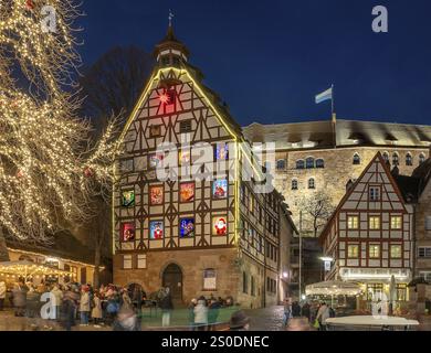 Pilatushaus, 1489 erbaut, ein historisches Stadthaus mit Adventskalender am 18. Dezember 2024 bei Dämmerung, das Kaiserschloss auf der rechten Seite, Tiergaertnert Stockfoto